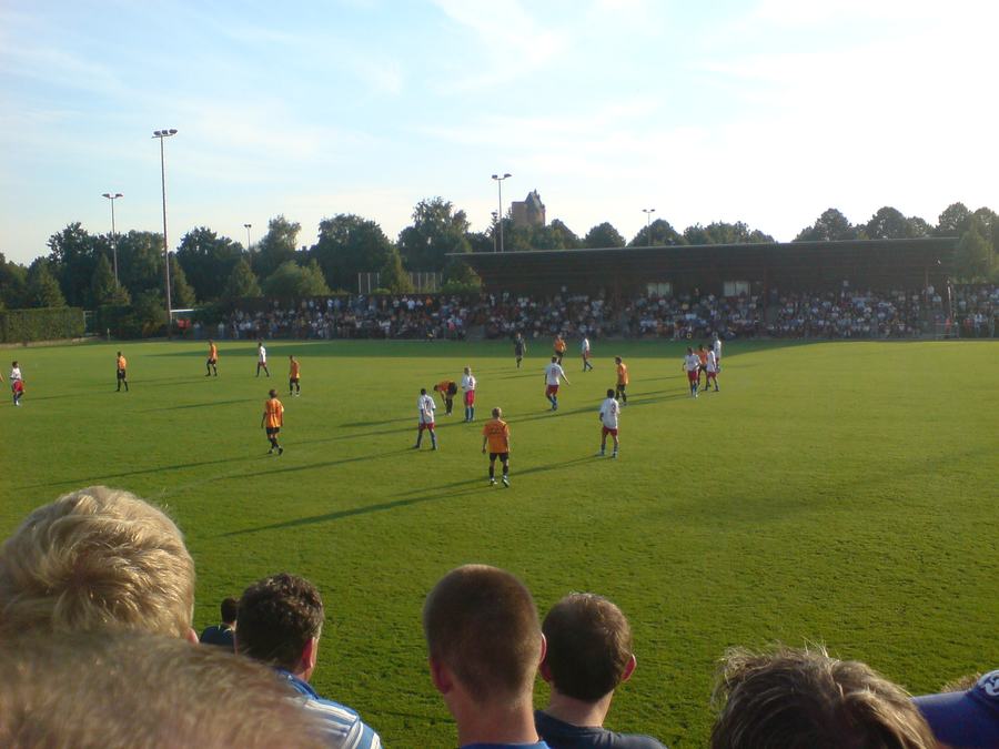 Empty red-railed concrete terracing at the Wolfgang-Meyer-Sportanlage under floodlights