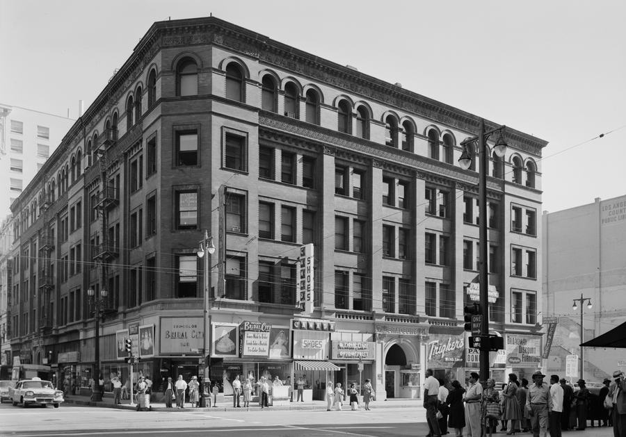 Black and white photograph of the Bradbury Building on a busy street corner in 1960