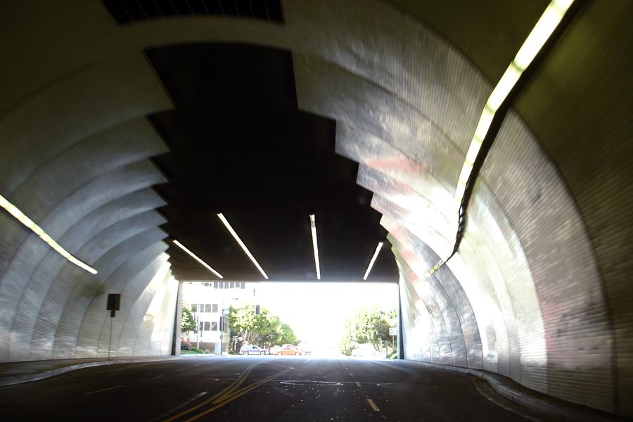 The white tiled barrel vault of the 2nd Street Tunnel seen from a car