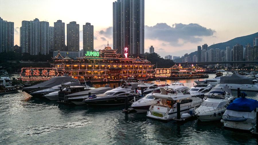 The Jumbo Floating Restaurant lit up at dusk in Aberdeen Harbour, Hong Kong, photographed in October 2010, weeks after the film unit built a Macau casino inside it.