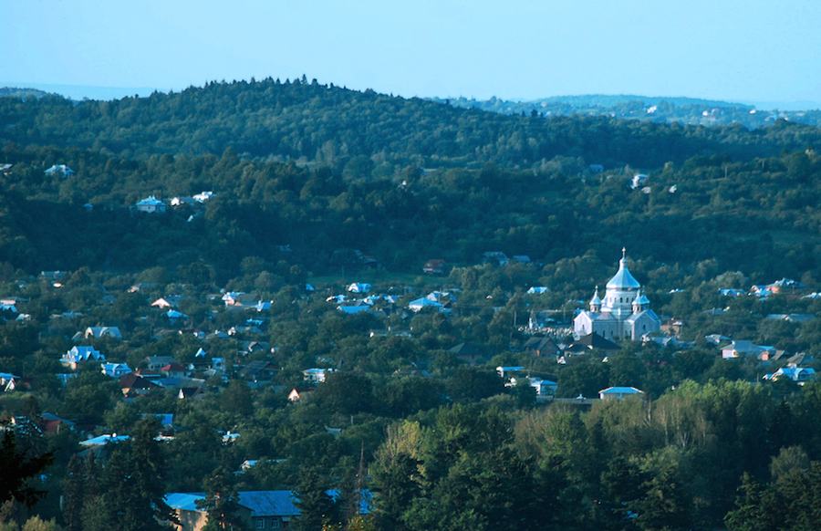 A small town spread across wooded hills with a domed church at its centre