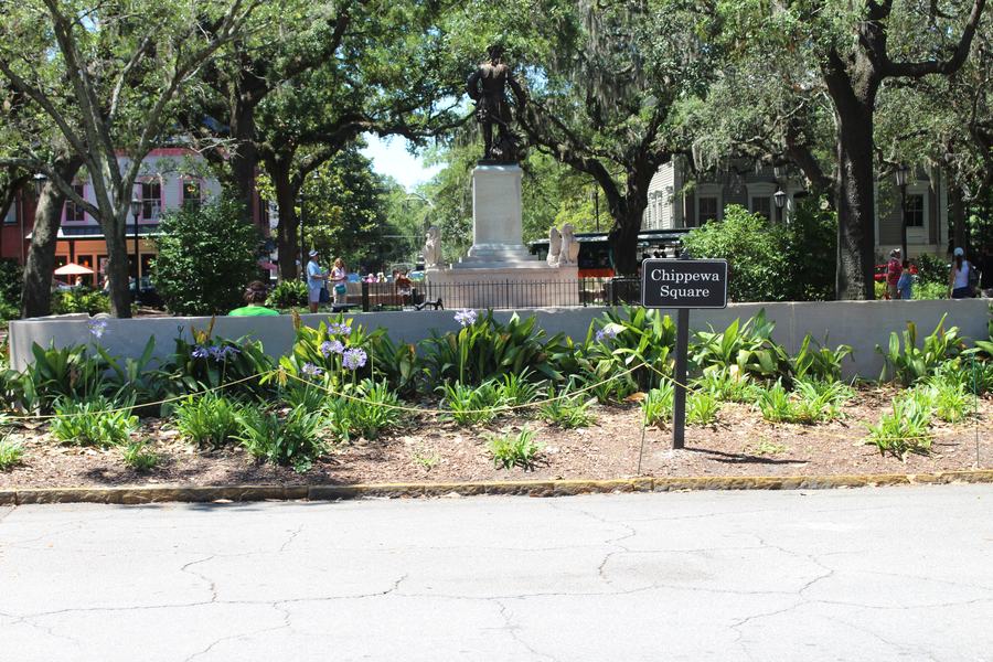 Savannah square with live oaks, planting beds and a bronze monument in the centre