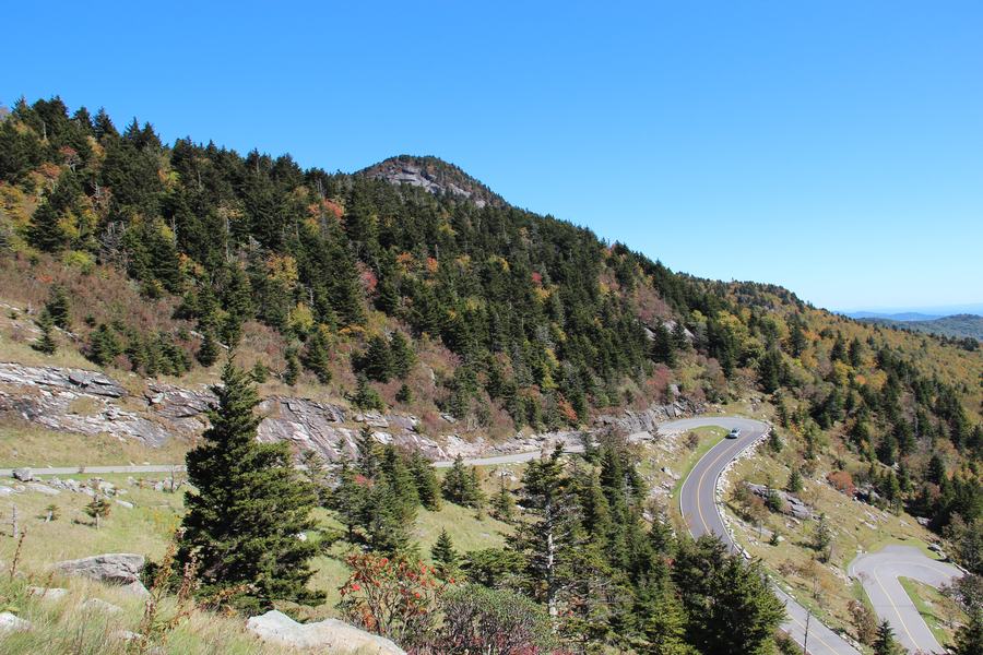Narrow paved road doubling back on itself across a rocky mountainside