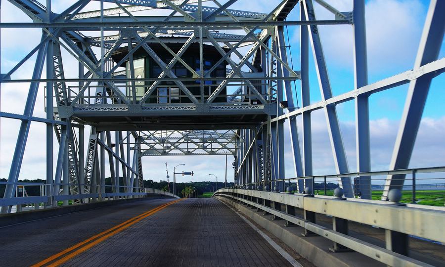 View through the steel truss of a swing bridge from a car on the roadway
