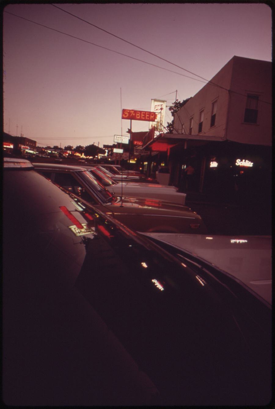 Neon-lit commercial strip at dusk near Bagnell Dam, Lake Ozark, Missouri, 1970s