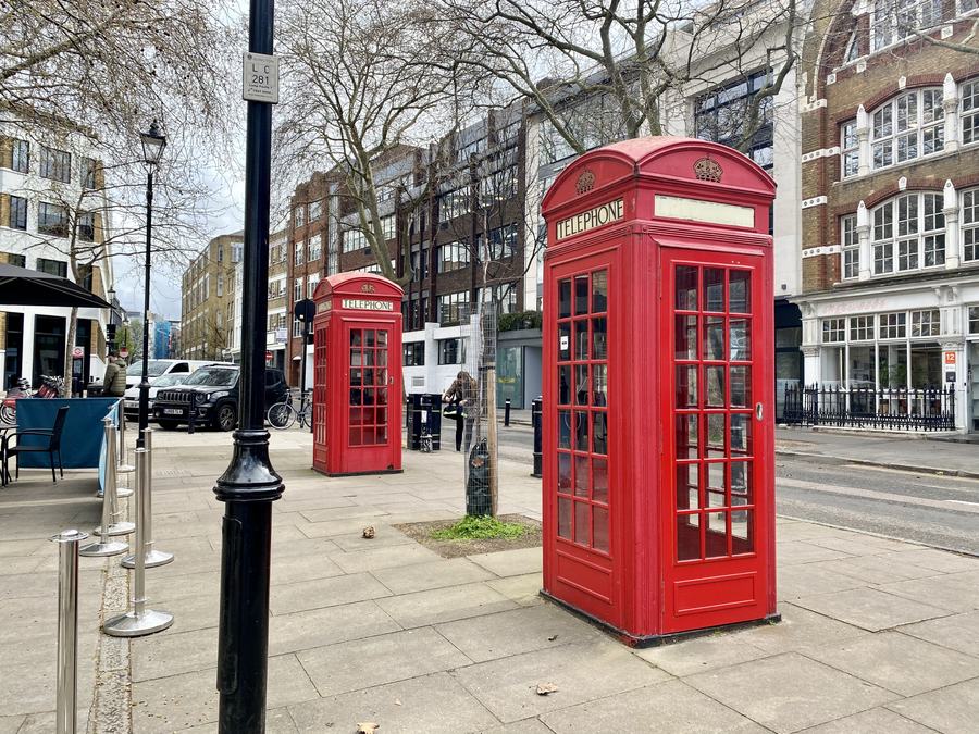Two red K2 telephone kiosks standing on the pavement at Clerkenwell Green, London EC1, with Georgian buildings behind.
