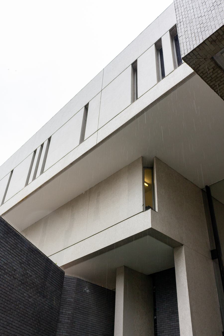The white cantilevered upper storey of the Royal College of Physicians standing clear of the dark blue engineering brick below it.