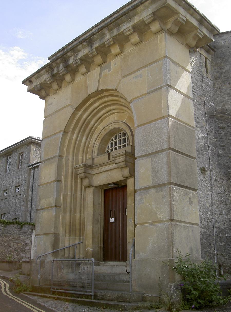A tall arched stone doorway in the outer wall at the north entrance to Shepton Mallet prison.
