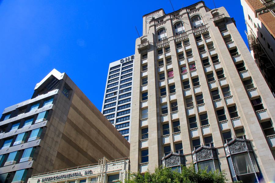 Narrow art deco tower with decorated bay windows seen from street level