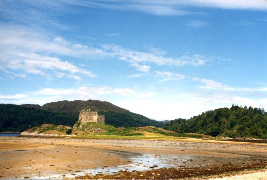 Castle Tioram photographed in 1987 across wide wet sand flats at low tide