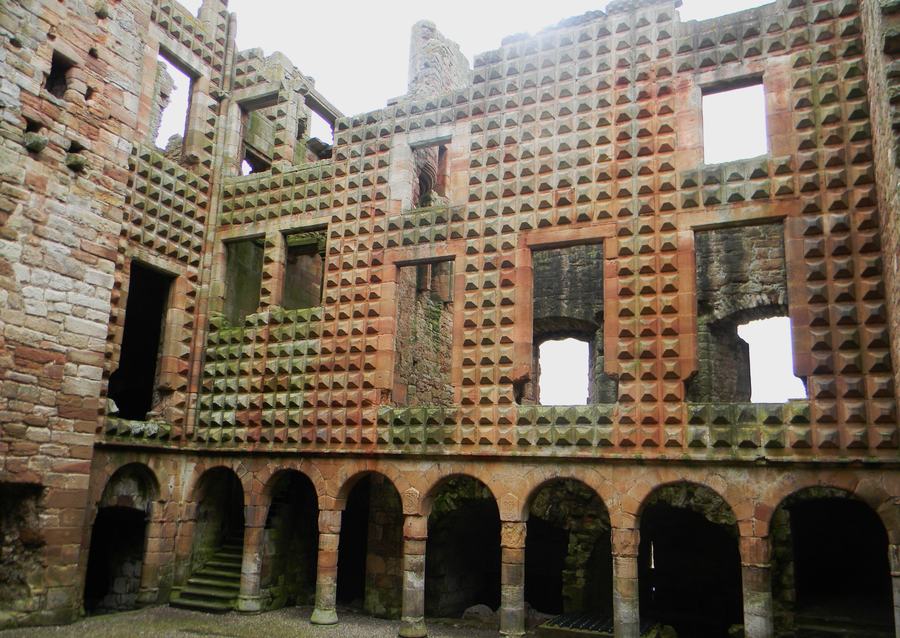 Courtyard wall at Crichton Castle faced with hundreds of projecting diamond-shaped stone blocks above an arcade
