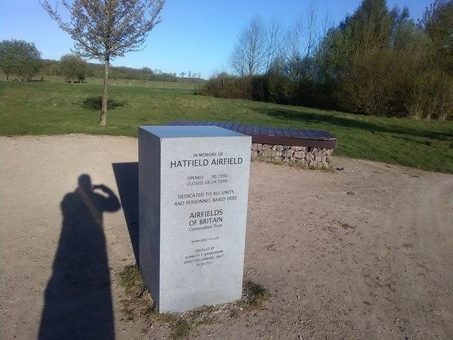A grey stone marker on grassland reading in memory of Hatfield Airfield, opened 1930, closed 1994