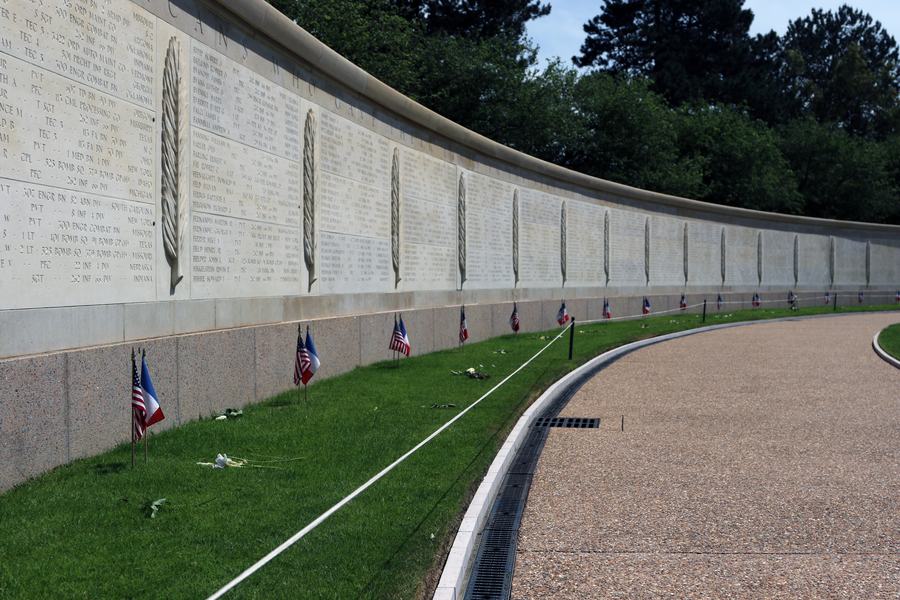 Curved stone walls inscribed with names in the memorial garden of the Normandy American Cemetery