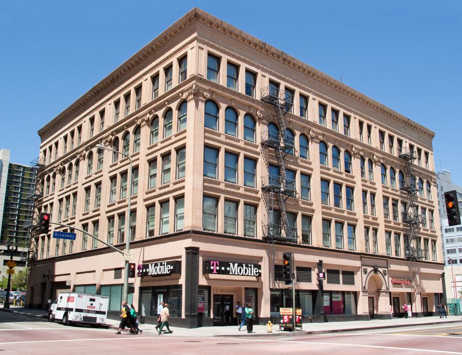 Five-storey Classical Revival brick and terracotta building on a street corner with arched fourth-floor windows