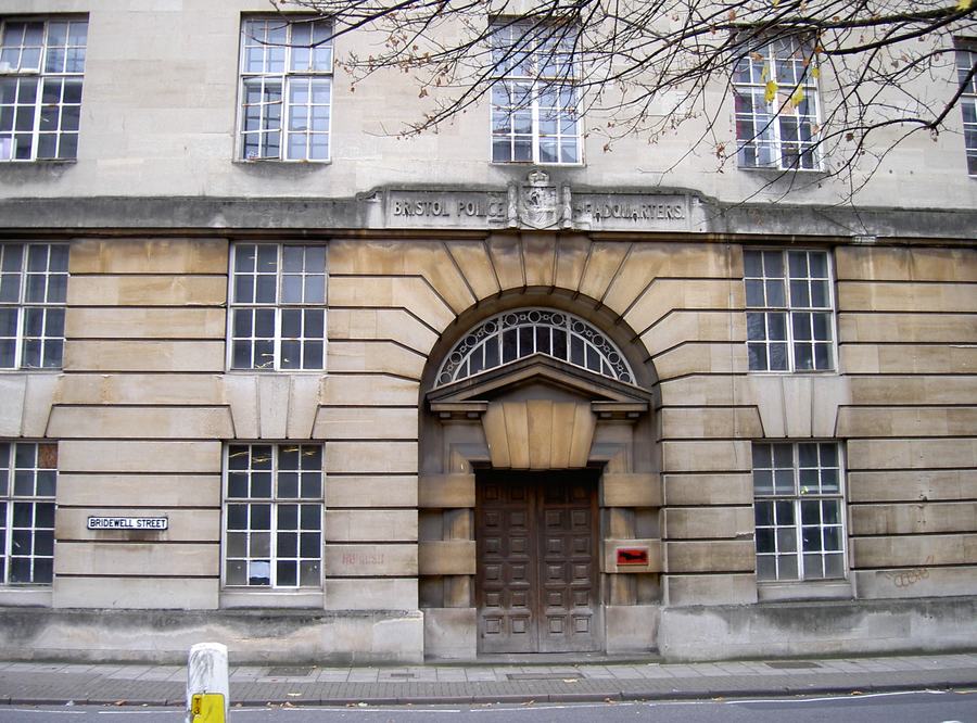 Stone facade with the carved inscription 'Bristol Police Headquarters' above an arched doorway, Bridewell Street sign on the wall