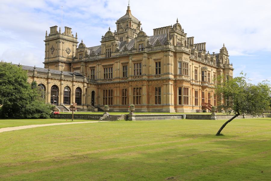 Victorian mansion with ornate towers and a terrace above a wide lawn, Westonbirt, Gloucestershire