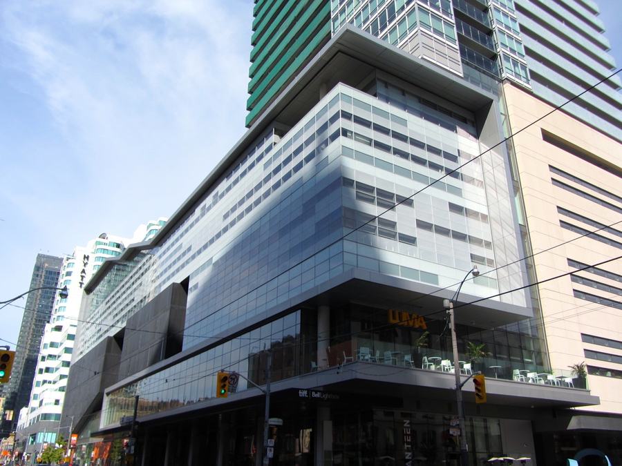 TIFF Bell Lightbox on King Street West with the orange LUMA sign above a second-floor terrace with white chairs