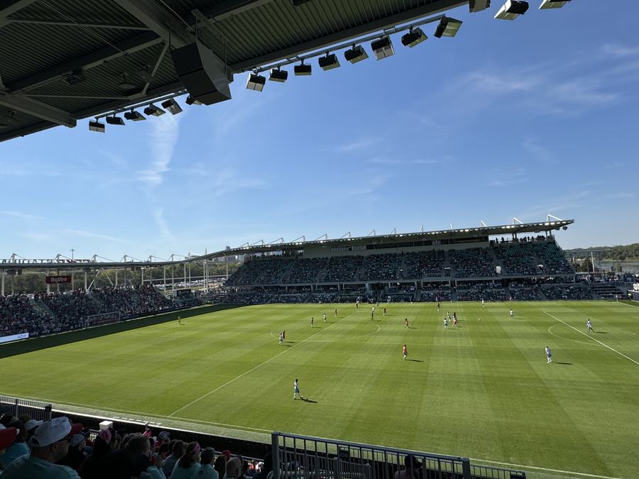 Inside CPKC Stadium during a women's football match, players on the green pitch in front of a modern stand