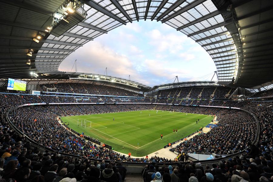A wide view inside the Etihad Stadium during a match, full stands under the open ring of the roof