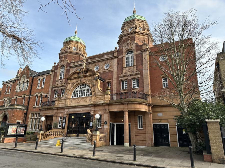 The red-brick and terracotta front of Richmond Theatre with its two green-domed towers